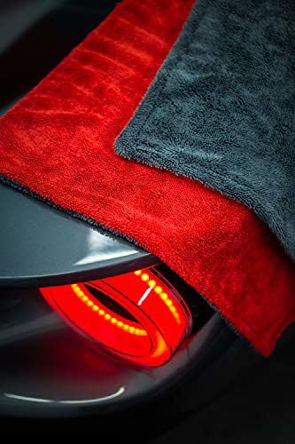 Stacked red and dark gray microfiber cleaning towels with plush pile and stitched edges
