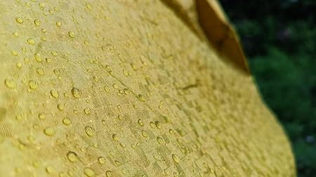 All weather car cover fabric, yellow with water droplets, textured waterproof surface
